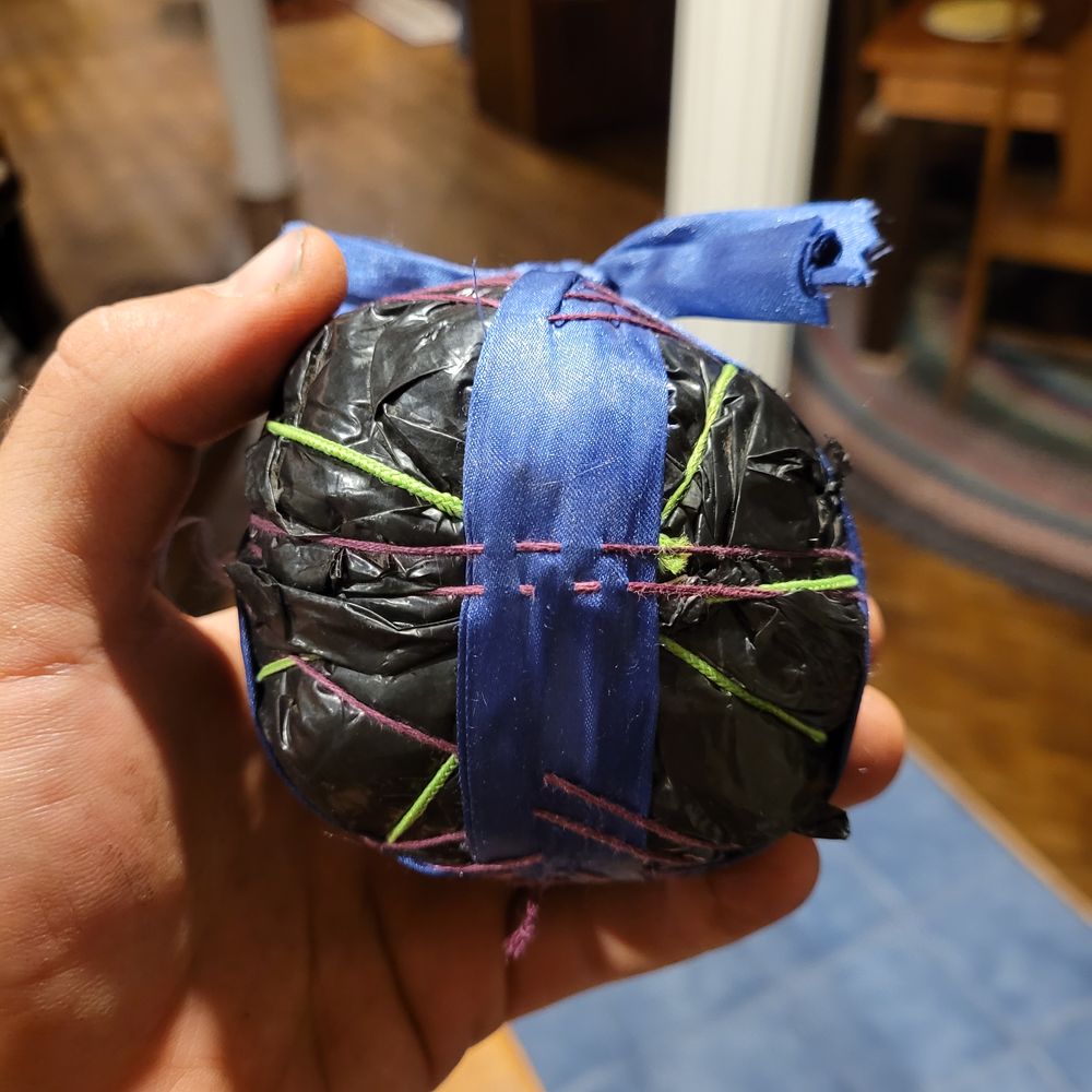 A talking ball made with (apart from the red thread, green elastic, and blue lace) plastics that I found on the ground.
