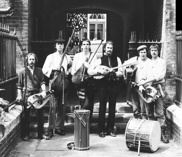 Blowzabella. Photo shoot for the first album cover. 1982. Photo: Ian Martin. St Paul's churchyard Covent Garden, London - the actor's church where Samuel Pepys first saw a Punch & Judy show in the 1660s. Like Punch and Judy (Pulchinella) the name 'Blowzabella' has its origins in Italian theatre of the 17th century.