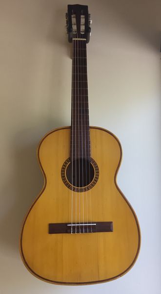 Small scale “Made in Brazil” off brand Nylon String Guitar. Right handed. Comes with case.