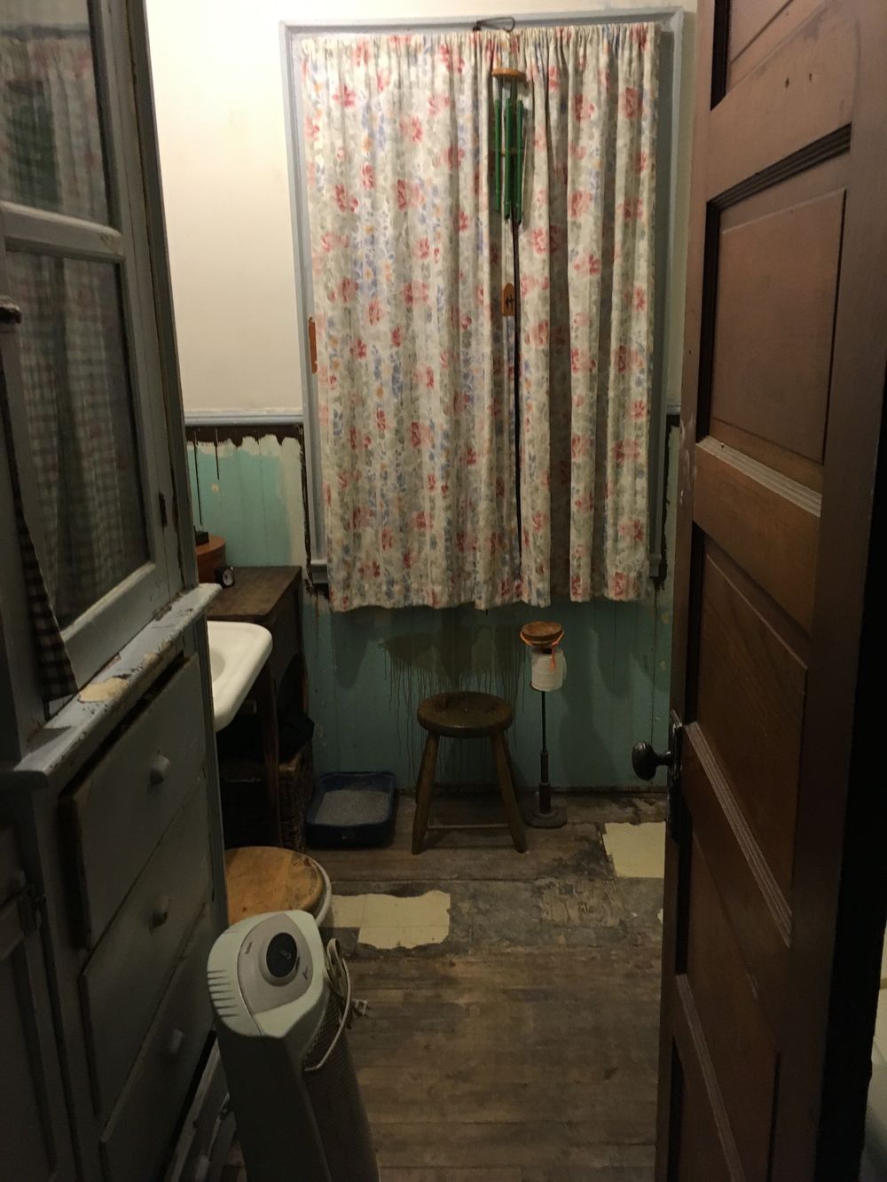 The upstairs bathroom with the paneling off the wainscoting and the visible damage to the floor. The areas where the creamy tiles are visible is plywood and needed to be replaced. I took up about half of the visible flooring and relaid it along with the pieces that I purchased