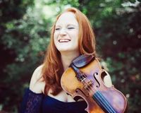 “Natalie Gain brings her own style of fiddling and vocals to the stage. With her high energy approach you can expect to hear a wide range of material from bluegrass to country and Gospel music.