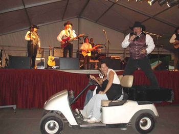 2006-It's hard to compete with Keith during the "Orange Blossom
Special." Ken jumped on the back of this cart during his
harmonica solo and had them drive through the pavilion. You
can't blame them for looking a little baffled