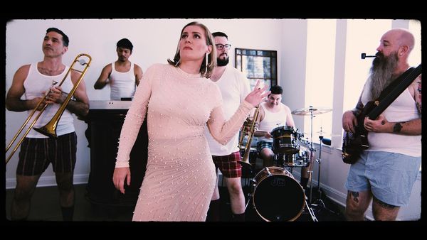 A picture of Cara Van Thorn in which the lead singer Carrie is in a very nice dress, and all other band members are in their underwear