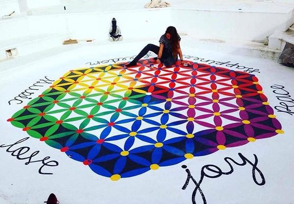 Charlotte Archer painting colourful floor mural in Ibiza
