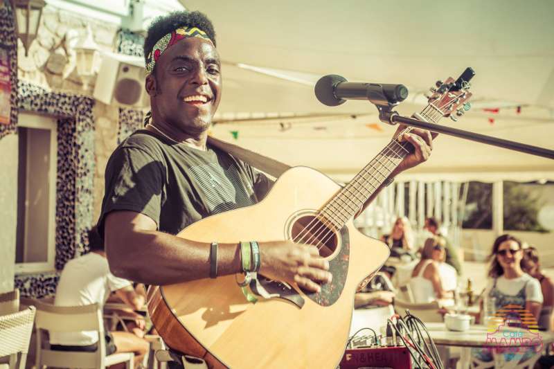 I See Hearts - Ryan Koriya beaming smile performing at Cafe Mambo Ibiza with acoustic guitar