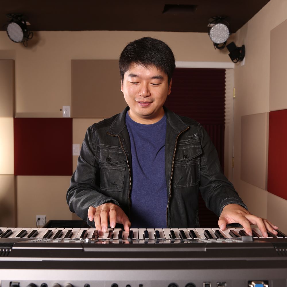 Tony Chen composing music at a keyboard