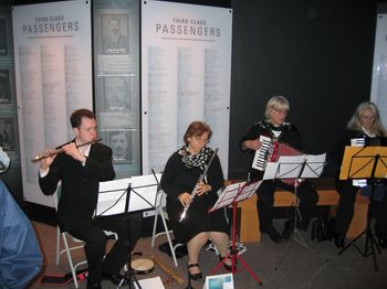Performing on flute in the docks of Liverpool, Mark Jones participating with members of a.P.A.t.T. Orchestra