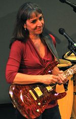 Stephanie Thompson smiling with her electric guitar