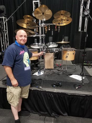 Me with a new configured Hybrid Kit featureing 2 - 3 mounted Arbiter Flats, 3 Floor Toms, Arbiter Flats Pancake Snare Drum, Several different metalic and orgainic percussion instruments a beautiful array of Amedia Cymbals and at the center an incredibly diverse Cajon