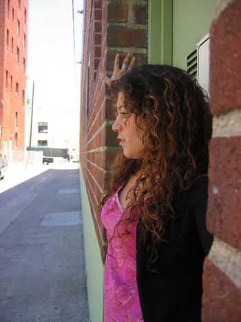 Zanya Laurence Music Soul Theory R&B Black Sweater Pink Top Curly Hair Blocking Doorway Brick Wall B