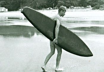 Ross on a coolish summer day at Waipu Cove ...January 1960 Ross carrying Dons unfinished board after trying it out (without any wax)....How good is the shape of that board for a 1960 model...impressive!!...