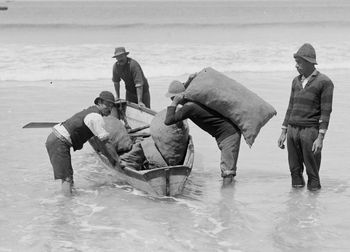 Ahipara 'shippies' 1917 imagine rowing this little narrow boat out through the surf at Ahipara ...fully laden with gum...wouldn't want a sneaker set to come thru..would you!!!!
