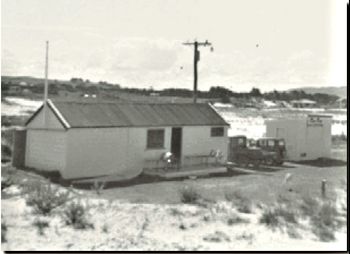 the Ruakaka SLSC humble beginnings 1961...the shed cost 10 pounds... after a big storm, we would have to dig the sand away from the doors to get into it.....how classic are those old cars!!!....that was a little weekend shop on the right.......ah..remember those early simple uncomplicated days of the early 60s!!...