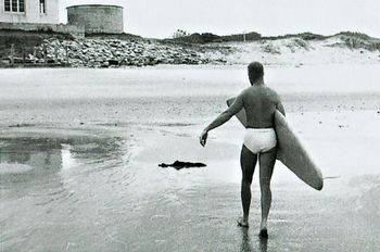 Terry Edge after a satisfying session at Waipu ..summer of '62 The old (surfclub) clubhouse up the top with the old watertank and sandbags to stop the erosion....