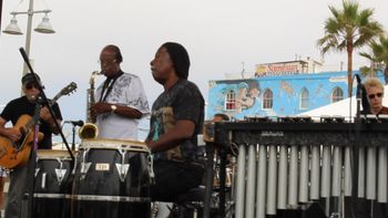 A Day in Venice Beach California Joe Gaeta - Guitar, Jack Fulks - Reeds, Steven McGill - Conga Drums, Gene Sone on Drums although you can only see the top of his head. Mike Mowen is actually playing Bass Guitar although the picture doesn't show it.