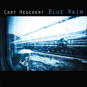 Cary Heuchert - "Blue Rain" (2014) Front cover. I took this photograph while traveling on a blue rainy day, in southern China in July 2006. Dongguan Train Station, Guangdong province, China. Photograph copyright © 2006 Cary Heuchert