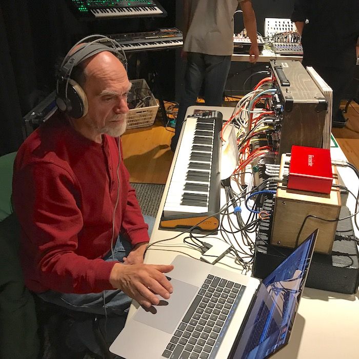 Image of: MW Gilbert seated at synthesizers