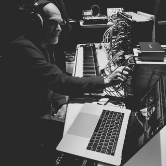 Image of: MW Gilbert seated at synthesizers