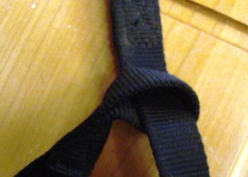 Purse the top end of the net bag closed by threading the small loop end of the strap through the large loop and draw tight, then attatch the lead to the small loop using the "wrap the strap" knot