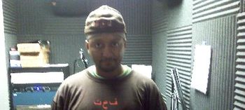 J.O.T aka GRANDE GATO doing pre-recorded interview on new third book published(I COULD HAVE GOTTEN REVENGE BUT I DIDN'T) at 102 JAMS wearing shirt with name his name, J.O.T., in ARABIC writing.