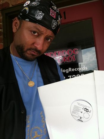GRANDE GATO HOLDING HIS 12 INCH VINYL RECORD OF HIS MUSIC IN FRONT OF MUSIC STORE UNDERDOG RECORDS pt 2.JPG
