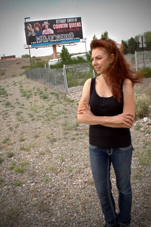 Bethany poses near her "Country Queens" promotional show billboard from the San Felipe Hollywood Casino, NM