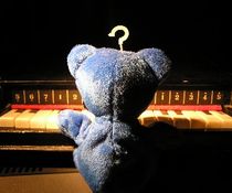 the blue bear seated at the piano