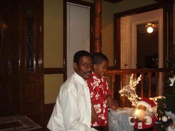 Minister James Branch & friend admiring Santa and his reindeer! And maybe trying to sneak a peek at what' s in the bags!