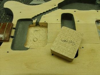 A maple plug was cut to fill a previous third pickup rout. The rout was rerouted nice and clean, and the filler plug fit perfect. The plug was then glued, clamped, and leveled. The neck pickup cavity was then routed to the correct dimensions.