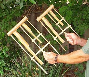 These are bamboo hand chimes known as Angklungs, another Vietnamese percussion instrument. The two pictured here are tuned to "C" and "A", each with two bamboo tubes tuned in octaves. These are just part of an entire set of eight. Originally Vietnamese farmers fastened them to bamboo polls and placed them around their fields. As the wind rattled the chimes, birds were scared away from eating their crops. In other words, they were used as "musical scarecrows".