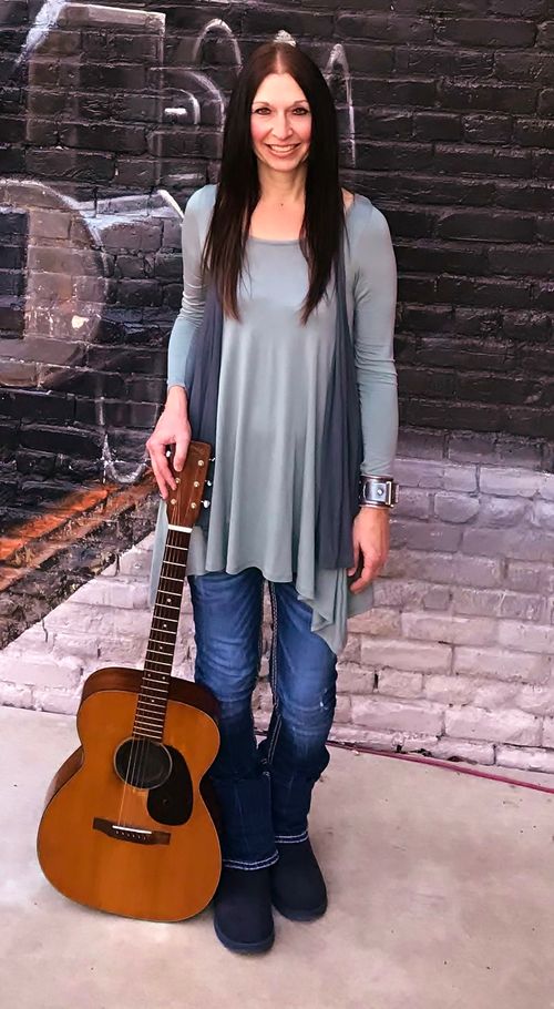 Austin Texas Singer/Songwriter Kimberlee M. Leber with her Martin guitar getting ready to perform