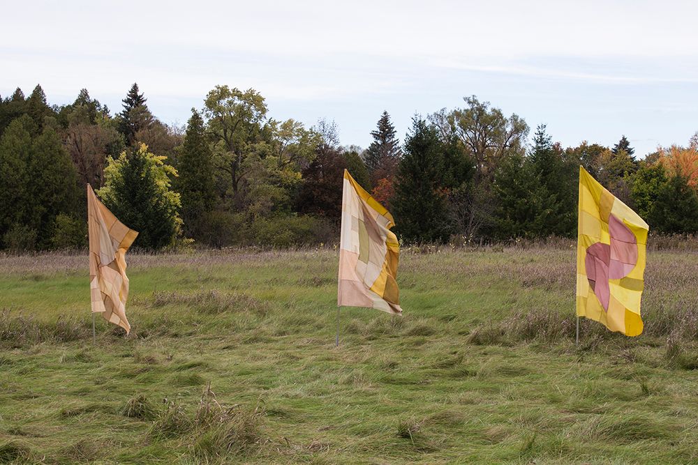 "Infinite Balance", 2021. Naturally dyed silk, wool, cotton, linen, and hemp, flag poles.