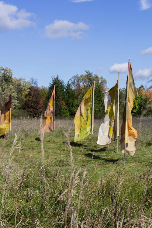 "Infinite Balance", 2021. Naturally dyed silk, wool, cotton, linen, and hemp, flag poles.