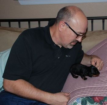 My husband, Lenard, playing with her. He thinks that this one puppy in a litter thing is the way to go!! :)