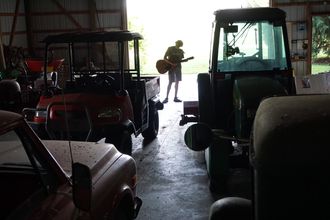 Jonathan Townley playing his guitar in his grandfather's barn. (photo: Neil Harvey)