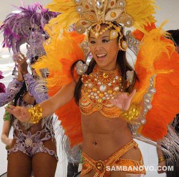 Wearing a glamorous orange Brazilian bikini is a dancer doing a Brazilian samba dance. Booking samba dancers is fast and easy