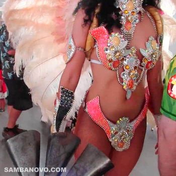 A close up of a samba dancer in an orange and silver Brazilian bikini waiting to dance at a wedding reception