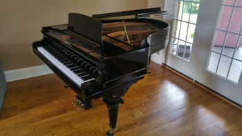 Same 1930's Kimball after 100's of hours of block sanding the cabinet. Refinished in High Gloss Black with New key covers and 1890's Knabe legs, scratch built matching Lyre. Set up in it's new home.