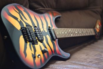 (01/07/14) This is a George Lynch signature model ESP Sunburst Tiger. The body is Maple with a Maple neck and Rosewood fretboard. It has a Floyd Rose Original bridge. It has a Seymour Duncan Screamin' Demon pickup in the bridge and a ESP single-coil pickup in the neck. The guitar is signed by Lynch himself on the back of the headstock. The guitar sounds and plays great but more then anything it is a real head turner.