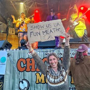 Girl holds sign in front of stage, Roxx Hunter rocks out with KingswardFish!