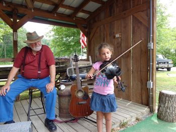 Golf Brooks watches as Veronica Royal or Quinton, VA  saws out a fiddle tune
