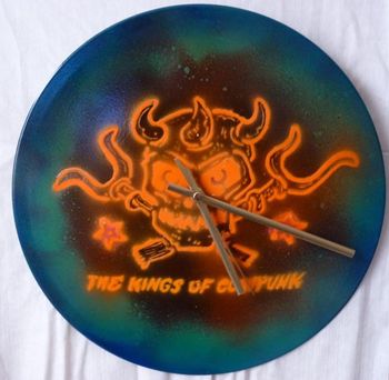 Pronghorn band logo clock on sprayed with orange and blue UV reactive paint on 10inch vinyl by G...£20 (search Old Son Designs on Facebook)
