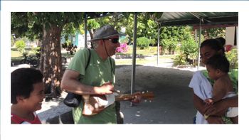 Lou playing Tahitian ukulele with singing kids on the atoll of Tikehau, French Polynesia
