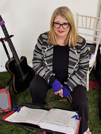 guitarist performing for a wedding booking outdoors