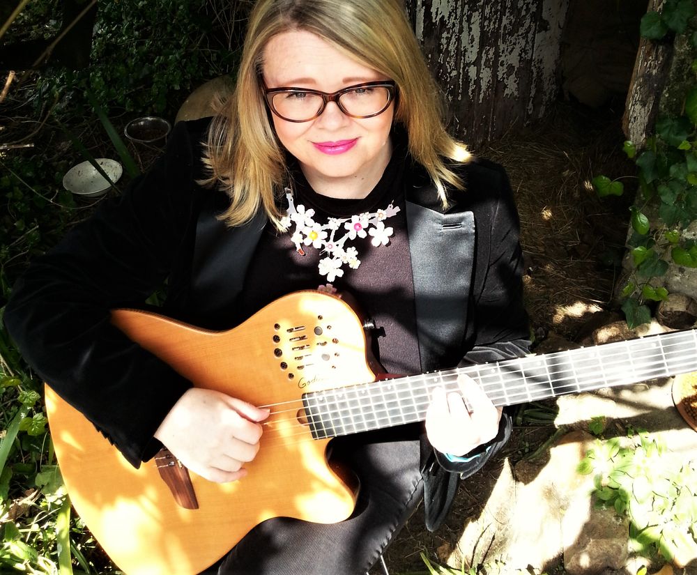 Solo Guitarist Carole playing outdoors