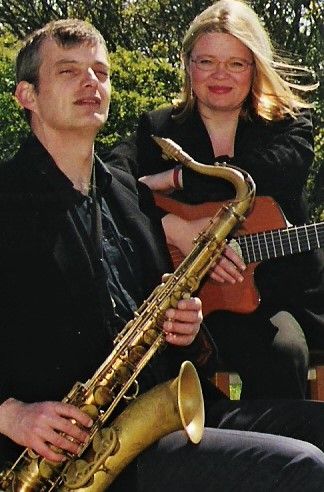 saxophone and guitar duo posing outdoors in Jersey