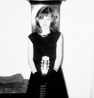 young guitarist posing with her guitar