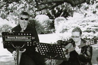 sax & guitar duo performing at a garden wedding