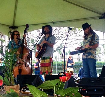 Performing as: Pat Simmons Jr. Ohana, live at the East Maui Taro Festival 2017. From left to right: Matt Del Olmo on upright bass, Pat Simmons Jr. on guitar & vocals, Justin Morris on dobro/lapsteel.
