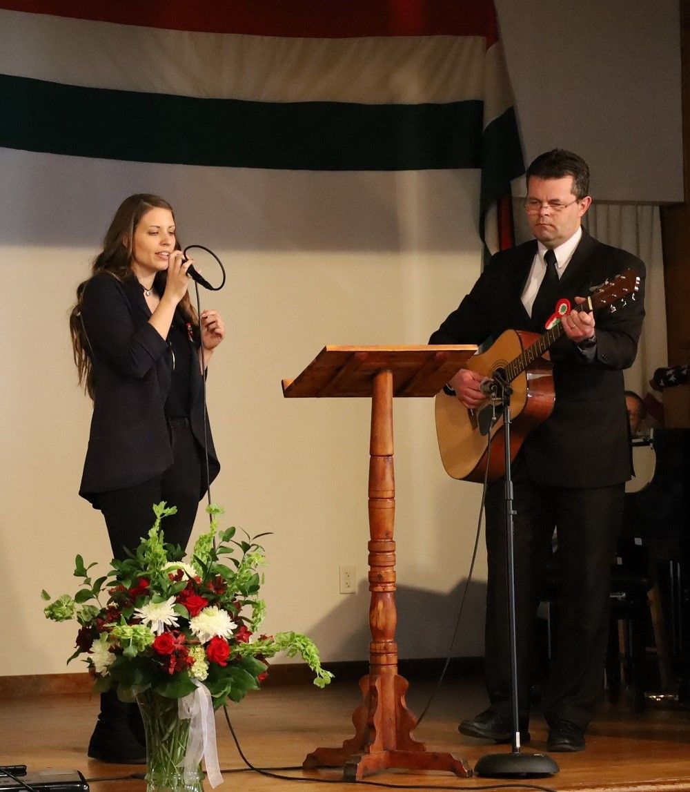 Szilvia Papp and Rev. Attila Tobias playing the guitar performing magyar songs
